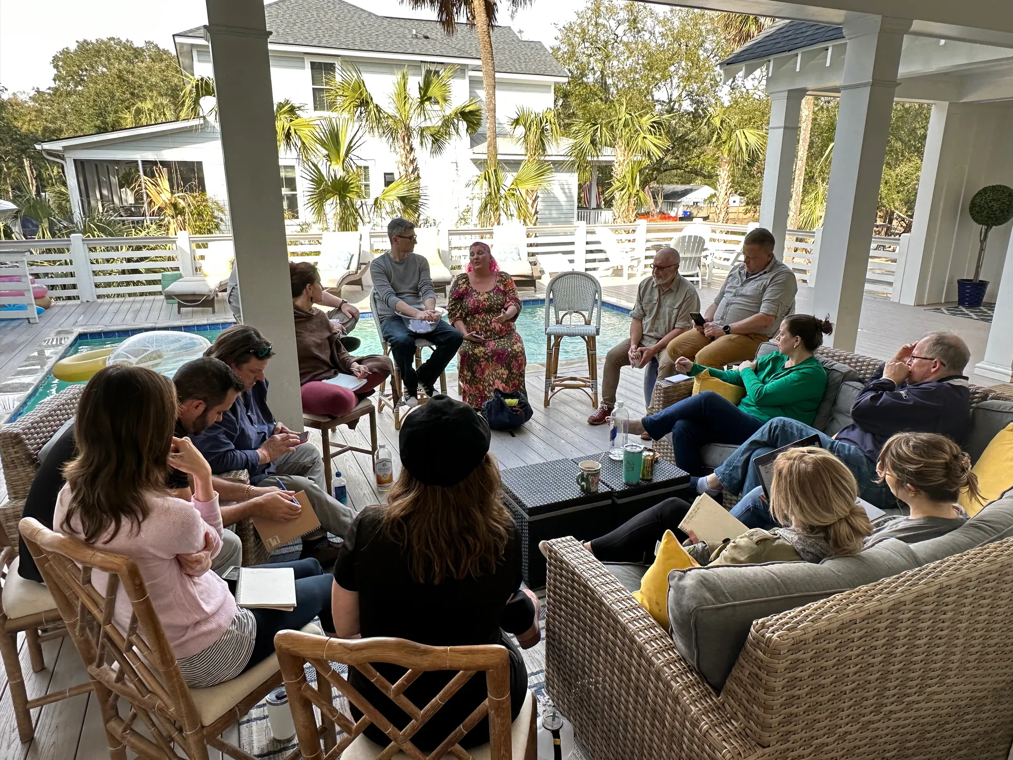 A guest coach presenting to a Huddle group around a long table