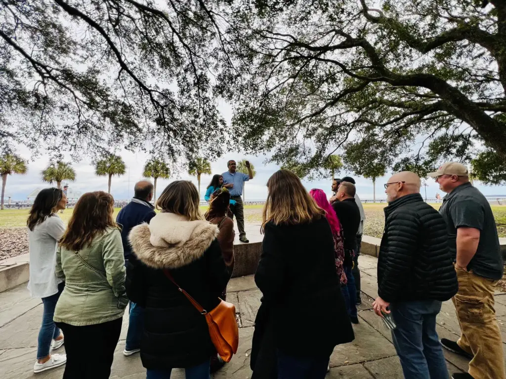 The group gathered in a circle outdoors with mountains behind