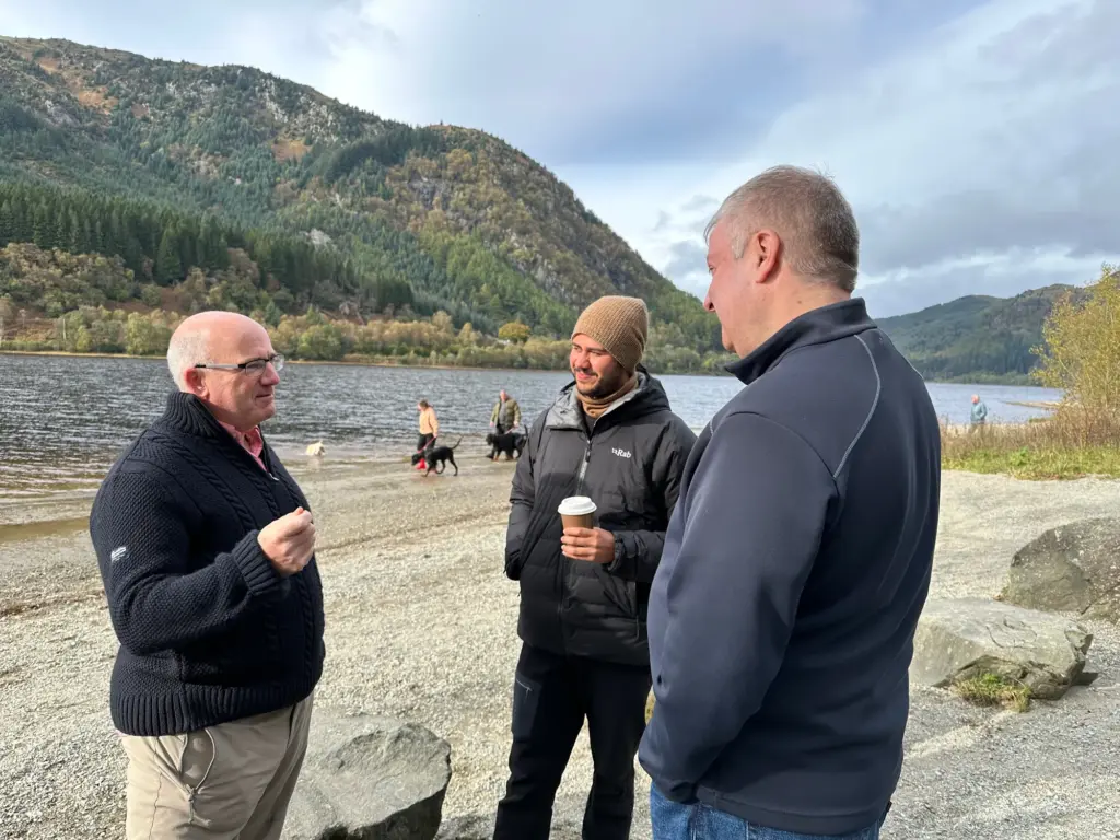 Three operators talking beside a Scottish loch