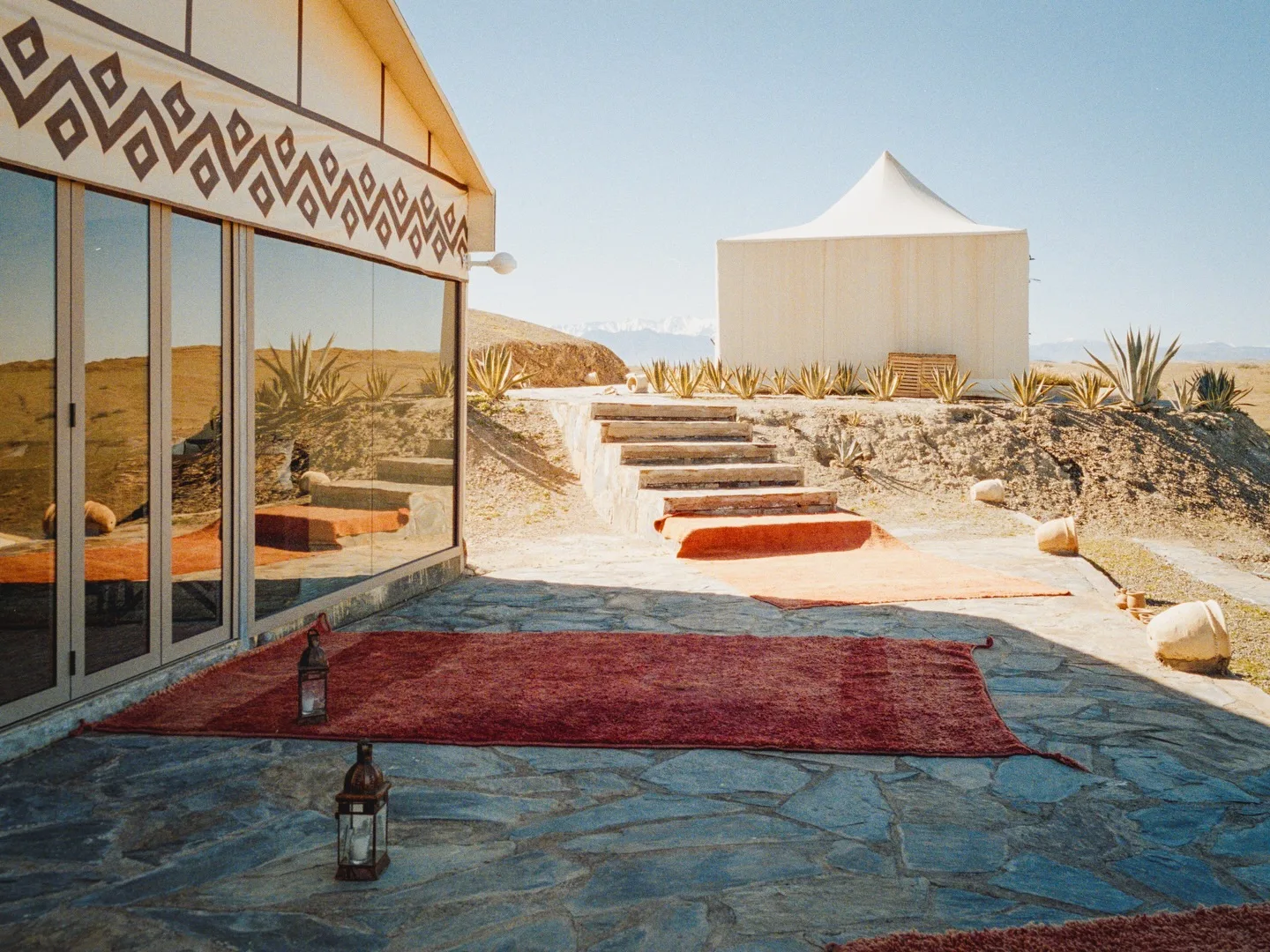 A group of travelers gathered on cushions at a desert camp in Agafay at sunset