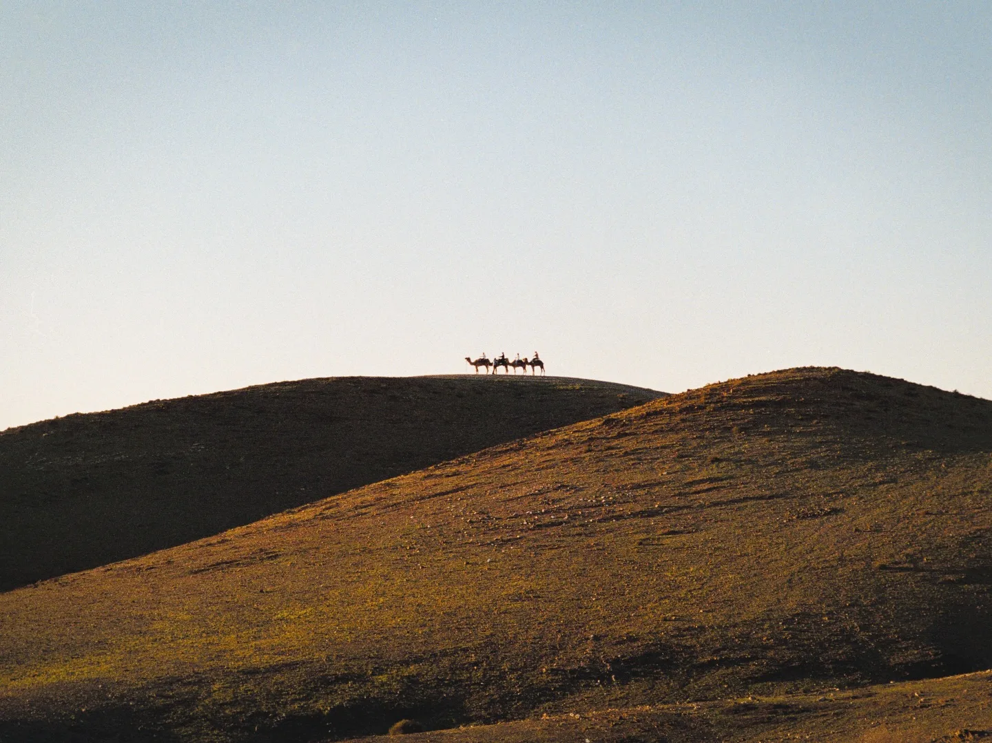 A group of travelers gathered on cushions at a desert camp in Agafay at sunset